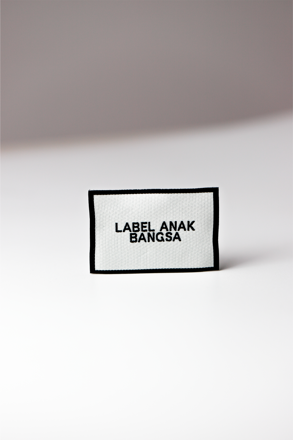 Label woven putih berbingkai hitam dengan tulisan Label Anak Bangsa
