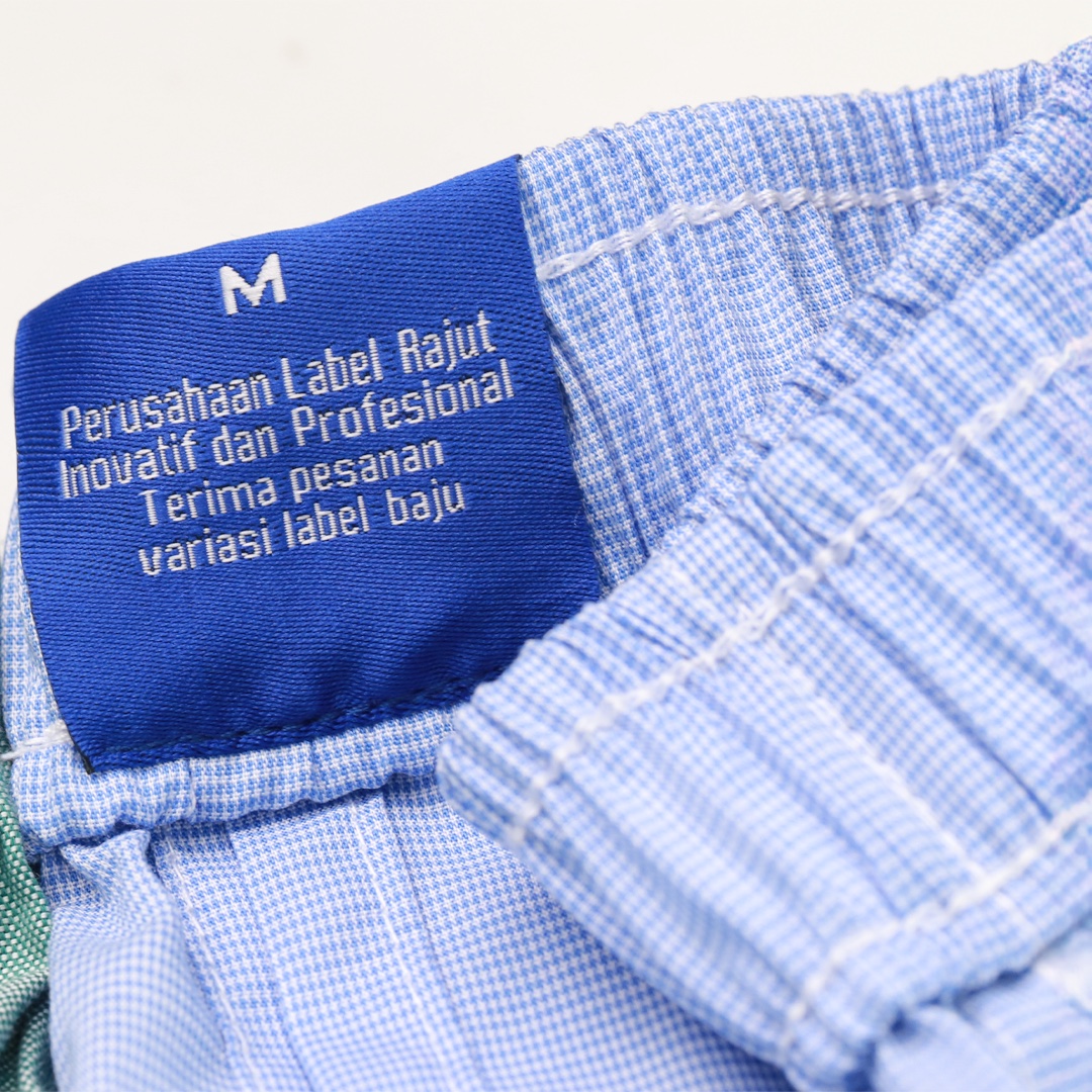 Care label tenun biru terpasang pada pakaian